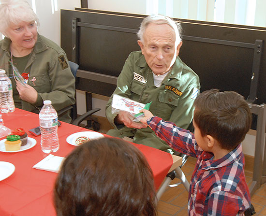 Child hands veteran a handmade card.